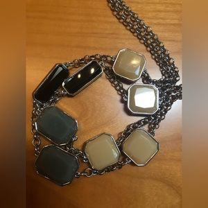 Chico’s long silver necklace with black, taupe, and gray stones.